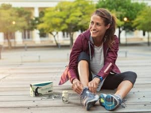 A fit lady getting ready to jog with Max products at her side